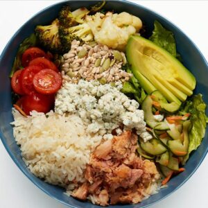 California Cobb Bowl Smoked chicken, avocado, roasted cauliflower, cucumber namasu, roasted broccoli, marinated cherry tomatoes, blue cheese crumbles, seed blend, your choice of grains with our greens blend and Greek dressing (served on side).