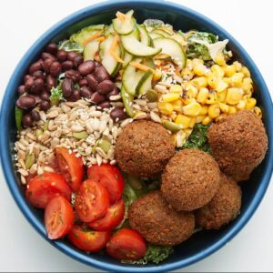 Edamame Falafel Bowl Crispy edamame falafel, cucumber namasu, roasted corn, marinated cherry tomatoes, black beans, seed blend, your choice of grains with our greens blend and Tzatziki dressing (served on side).