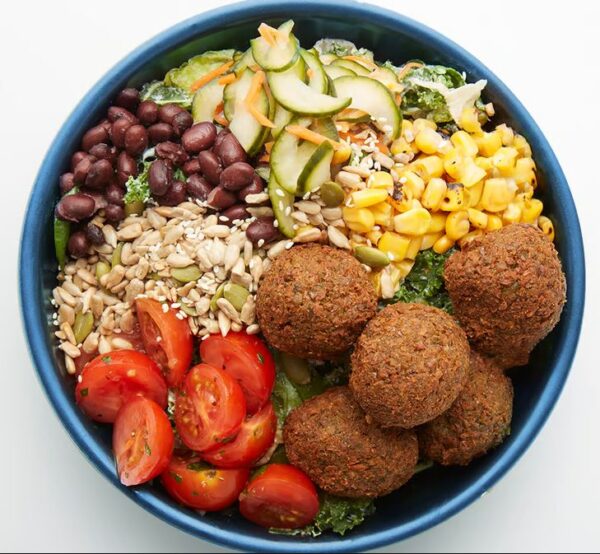 Edamame Falafel Bowl Crispy edamame falafel, cucumber namasu, roasted corn, marinated cherry tomatoes, black beans, seed blend, your choice of grains with our greens blend and Tzatziki dressing (served on side).